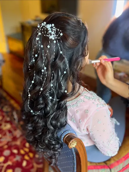 The cascading pearl accessory adds a touch of ethereal beauty to this romantic hairstyle. It's perfect for a bride who wants a dreamy look.