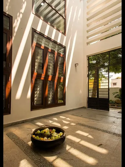 The play of light from the pergola creates dynamic shadows on the courtyard floor, changing throughout the day and adding life to the space.