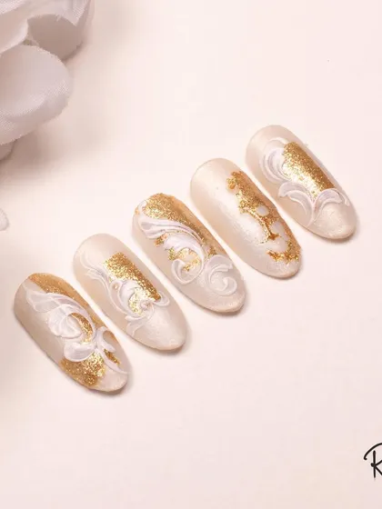 A stunning white and gold swirl design, perfect for a sophisticated and luxurious manicure.