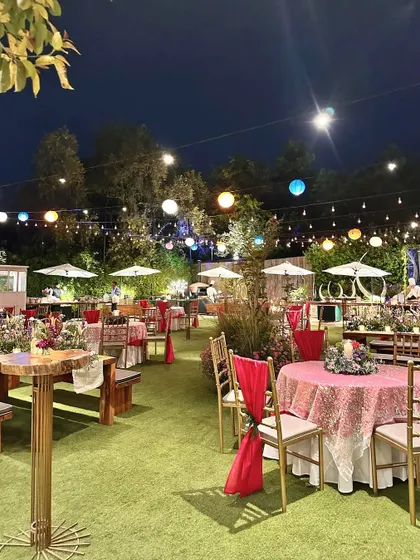 A vibrant Mehendi or Sangeet setup with colorful tablecloths, paper lanterns, and wooden bench seating.