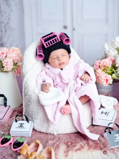 A day at the spa for this little diva. Dressed in a tiny pink robe with knitted hair rollers, she's ready for a day of pampering.
