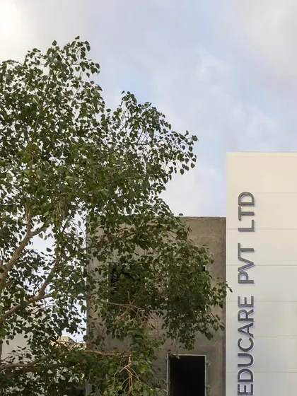 The new facade of Educare Pvt Ltd, seen alongside a mature tree, illustrates how our contemporary designs can coexist with and complement the natural environment.