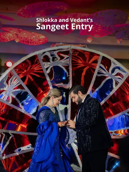 Shlokka and Vedant's Sangeet entry, framed by a vibrant, custom-made stained-glass-effect wheel. This unique backdrop made their ring exchange ceremony even more special.