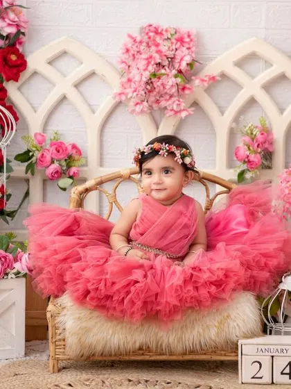 A royal portrait. Seated on her wicker throne amidst a sea of pink flowers, this little girl is the queen of her castle.