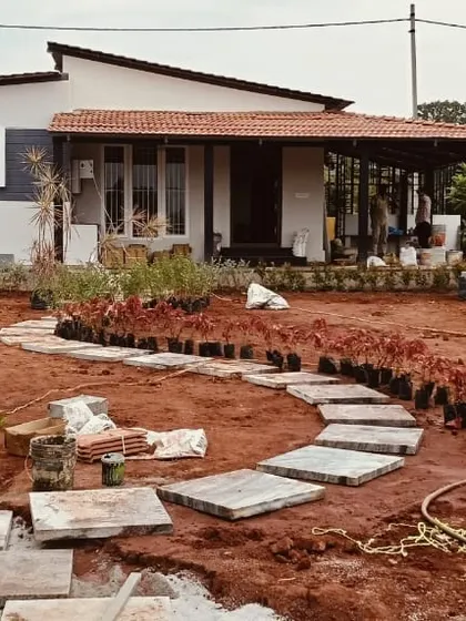 A wide shot of a garden mid-transformation, with the hardscape path laid and rows of plants ready for installation. This is part of my comprehensive design and execution service.