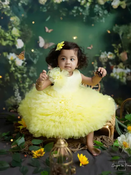 A little ray of sunshine in her yellow dress, this fairy is sitting in an enchanted garden filled with flowers and butterflies.