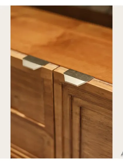 Craftsmanship is in the details. This shot shows the custom-designed metal handles on the wooden TV console, a small but significant element that adds a modern touch to the traditional material.