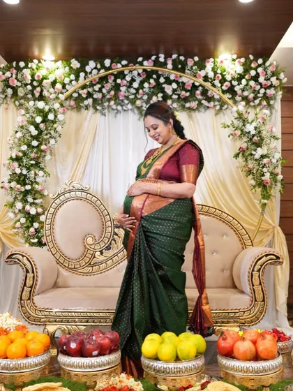 A full-length shot of Archana at her baby shower. The makeup is elegant and understated, allowing her natural happiness and the beauty of the traditional ceremony to take center stage.
