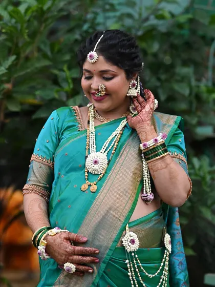 Adjusting the final touches. Every piece of floral jewelry, from the earrings to the armlets, is carefully placed to create a cohesive and beautiful look.