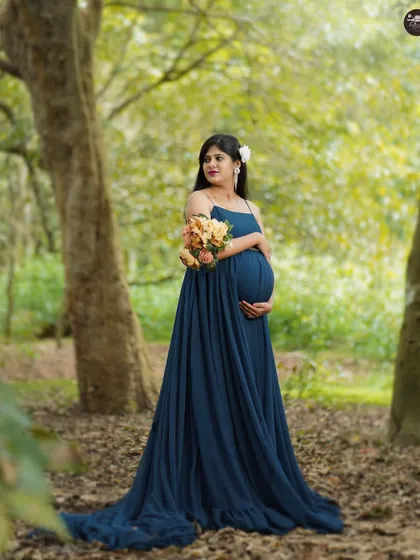 Standing amidst the trees, this portrait captures a feeling of peace and connection with nature. The flowing blue gown complements the greens of the forest perfectly.