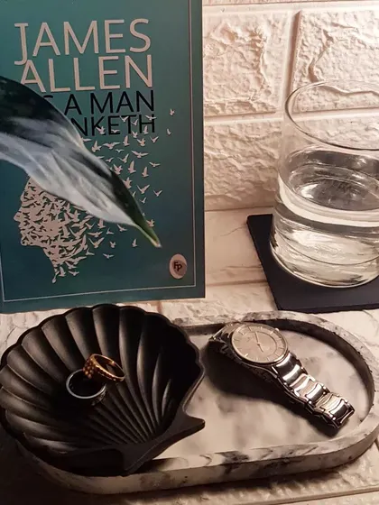 A black and white marble tray paired with a solid black shell dish and coasters. A very sleek and modern combination.