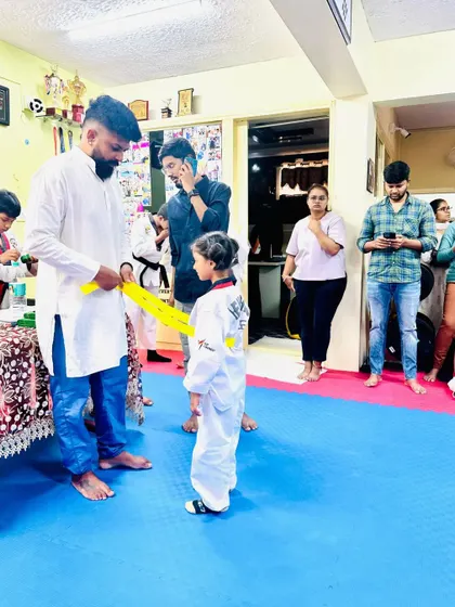 Another young student receives her well-earned yellow belt.