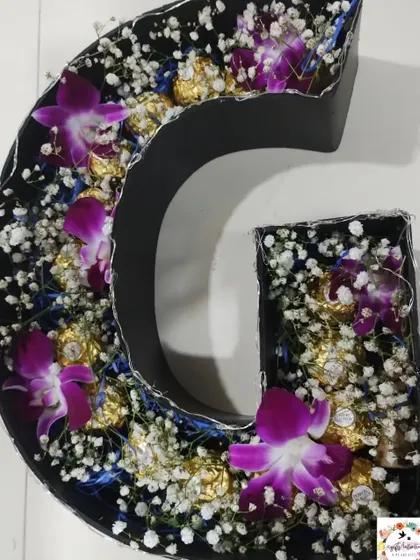 The alphabet bouquet before adding the fairy lights. It's filled with purple orchids, baby's breath, and Ferrero Rocher chocolates.