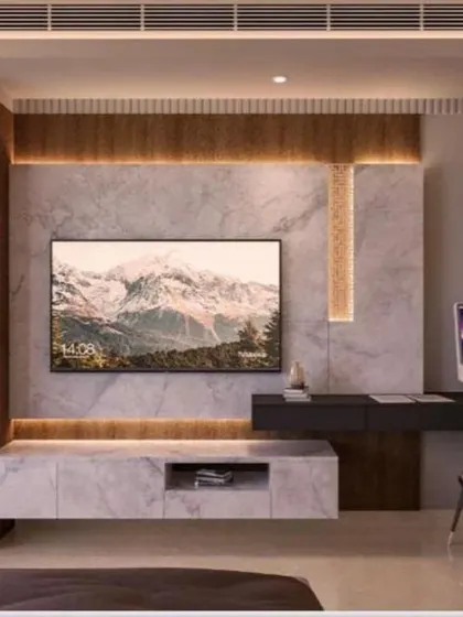 This bedroom combines a marble-clad TV wall with wood-paneled wardrobes and a sleek, floating study desk.