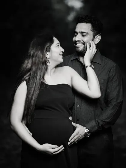 A beautiful black and white portrait of an expecting couple sharing a loving gaze. The natural outdoor lighting and monochrome finish create a timeless and emotional feel.