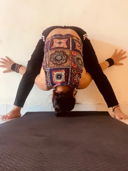 The wall can be your best friend in self-practice. Here I am in Kurmasana (tortoise pose), using the wall to deepen this intense forward bend.