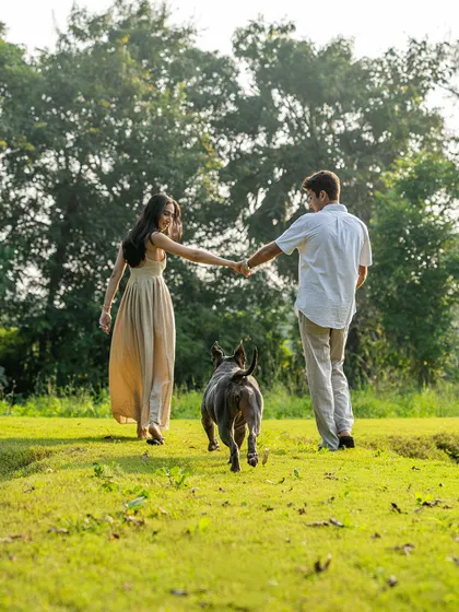 A romantic shot of a couple walking hand-in-hand with their dog, Millie, leading the way. This is a perfect example of how to create a beautiful and meaningful engagement photo that includes your pet.