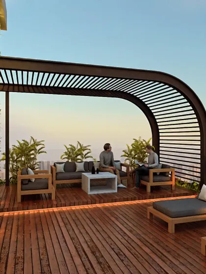 A rooftop terrace is more than an amenity; it's an elevated backyard. This design for Haresh Bhuvan features a wooden deck with comfortable lounge seating under a modern pergola, creating a perfect space for residents to relax and socialize.