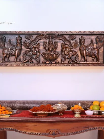 A 38-inch wall panel of Goddess Mahalakshmi with the wish-fulfilling cow, Kamadhenu. The antique copper finish gives it a unique and elegant look, shown here in a pooja setting.
