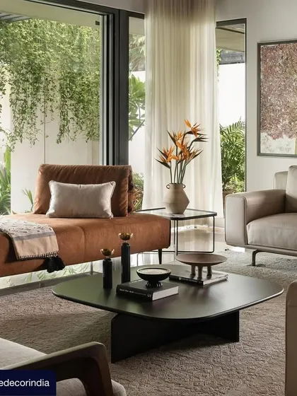 Another view from the Villa Shakthi feature, this image captures the serene ambiance of a seating area overlooking the garden. The large glass sliders and hanging greenery create a diaphanous connection to the outdoors, making nature an integral part of the interior experience.