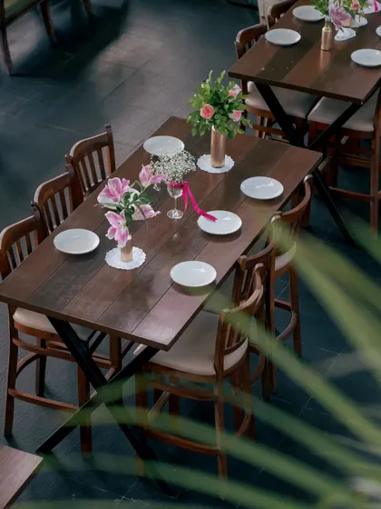 An overhead view of our long tables, set with simple white plates and fresh flowers. This setup is perfect for family-style meals, workshops, or collaborative corporate sessions.