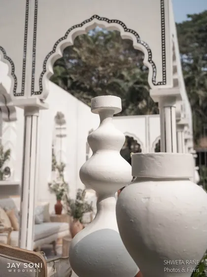 Sculptural white vases add a modern, artistic touch to the classic, traditional architecture of the lounge pavilion.