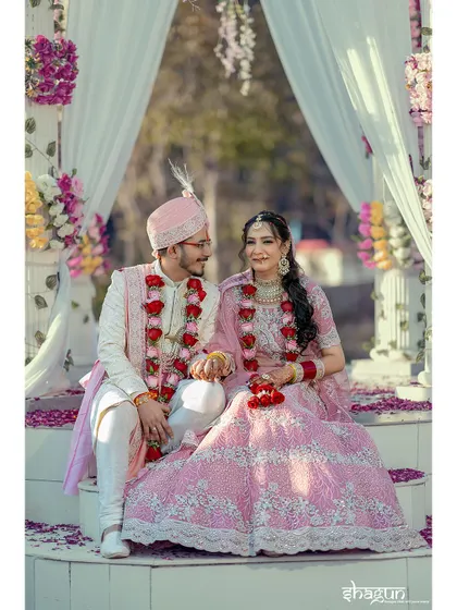 Seated at their mandap, the couple shares a quiet moment before the ceremonies begin. The floral decor adds to the romantic setting.