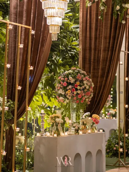 A floral arrangement featuring a large sphere of pink and white roses. This modern, sculptural approach to florals adds a unique design element to the decor.