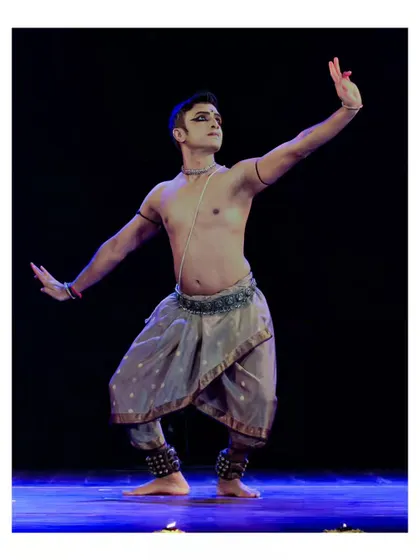 A graceful and powerful pose from a solo recital. The lighting highlights the form and musculature, showing the physicality of the dance.