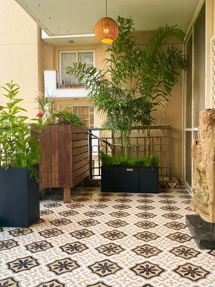 On the other side of the Palm Springs balcony, we placed a custom wooden cabinet for storage and display. It’s flanked by tall planters that add height and greenery, balancing the overall design of the space.