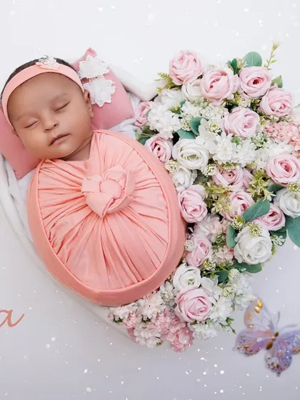 A personalized portrait of baby Ira, sleeping in a heart-shaped bowl filled with pink and white roses.