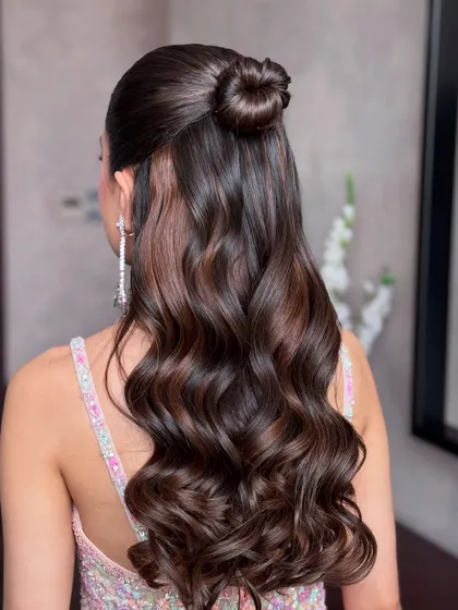 Another angle of the chic half-up top knot, showing the contrast between the sleek bun and soft waves.