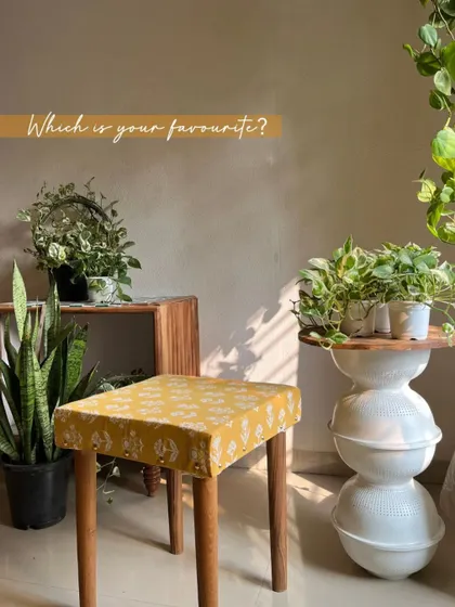 A close-up of the custom ottoman, upholstered in our yellow block-print fabric. It's a great DIY project and a perfect way to add a pop of color and pattern to your room.