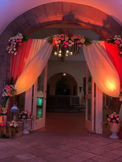 A beautiful example of how a well-chosen color scheme can define your decor. For this Catholic wedding entrance, we used drapes in shades of red and white with floral accents to create a welcoming and cohesive look.