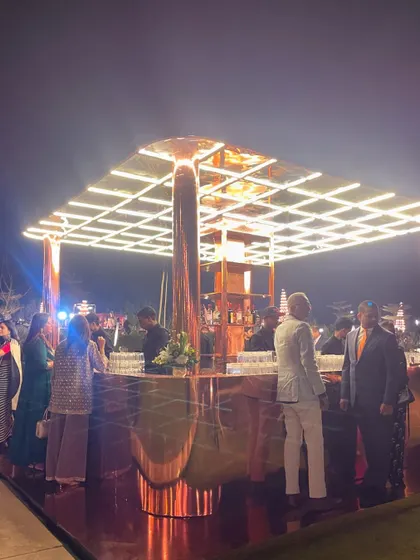 The bespoke polished copper bar glowing at this outdoor reception. Its warm, reflective surface and all-sides access made it a sophisticated focal point for the evening's celebrations.