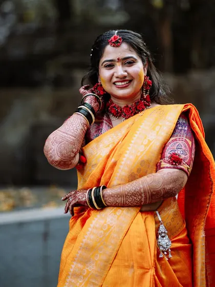 A beautiful portrait of the bride at her Haldi ceremony, dressed in a yellow saree with floral jewellery.