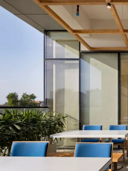 An outdoor terrace at the Godrej Woods Clubhouse extends the social spaces into the open air. This area provides a casual setting for dining or relaxing, blurring the lines between inside and out.