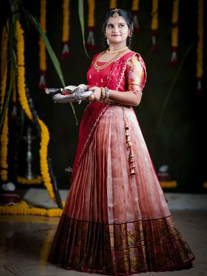 For the Makara Sankranthi festival, I designed this exquisite Zari Kota lehenga for my client. The peach skirt with a traditional border is paired with a red brocade blouse, creating a vision of grace and tradition.