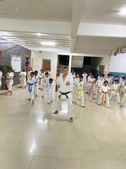 The class holds a strong zenkutsu-dachi (front stance) while practicing punches. A stable stance is the source of all power in karate.