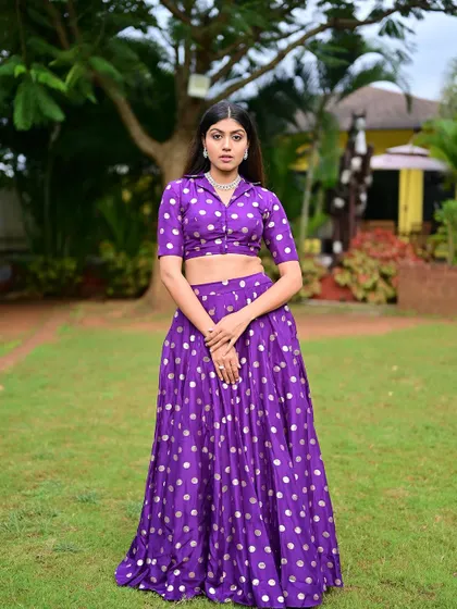 A full-length shot in an outdoor setting. The makeup is fresh and vibrant, matching the playful energy of the outfit.