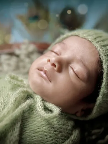 A detailed close-up of the baby's serene face during our Little Krishna photoshoot. We ensure your baby is always comfortable and peaceful, even in our most elaborate setups.