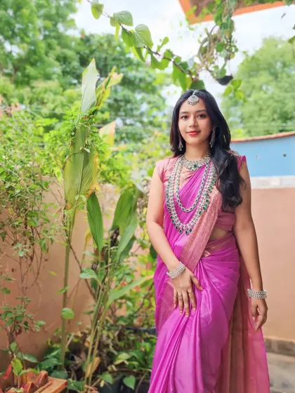 A full shot of the client in her beautiful pink saree, her look elevated by the sparkling American Diamond jewellery set.