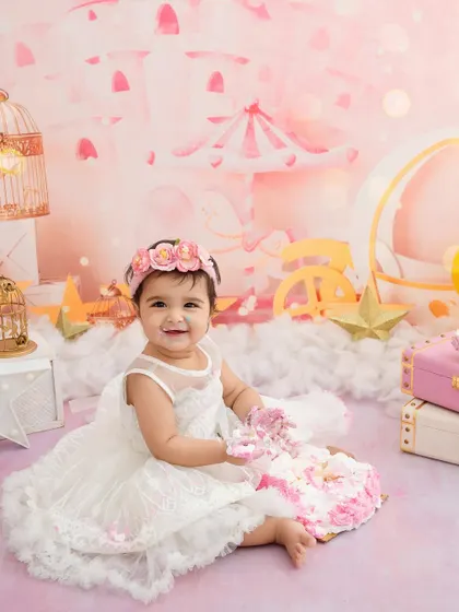 A princess in her castle. This little girl is all smiles as she gets messy with her cake in a dreamy pink fairytale setting.