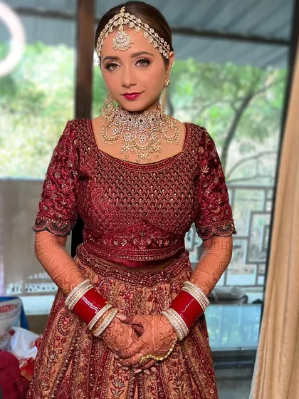 A portrait of the bride, showcasing the flawless makeup and beautifully set jewelry. The look is designed to be both traditional and radiant.