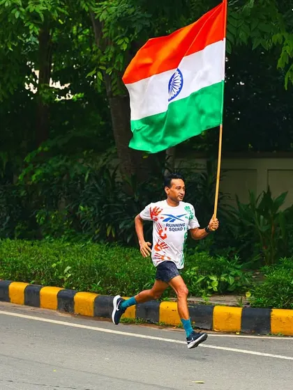 A runner in full stride, carrying the flag high. These are the moments that define our community spirit.