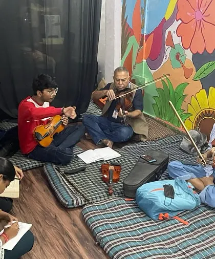 A mixed-instrument session in progress, with students on violin and guitar learning together. We encourage cross-instrument collaboration to create a richer musical texture.