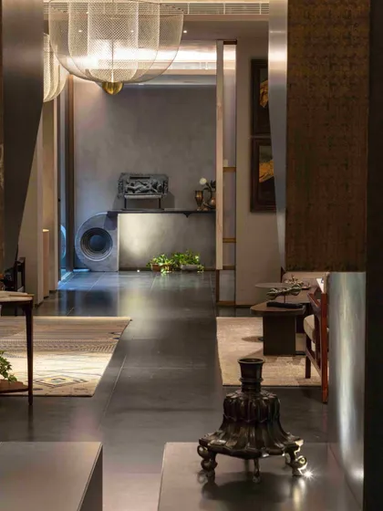 A long view through the formal living room, showcasing the dark, polished floors and the carefully placed art and artifacts that draw the eye through the space.
