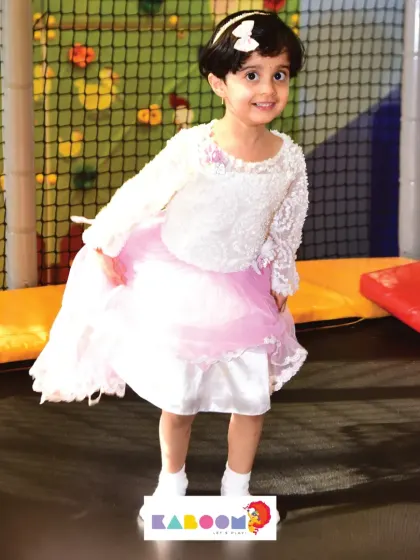 This little princess is having a great time bouncing on our trampoline in her beautiful party dress.