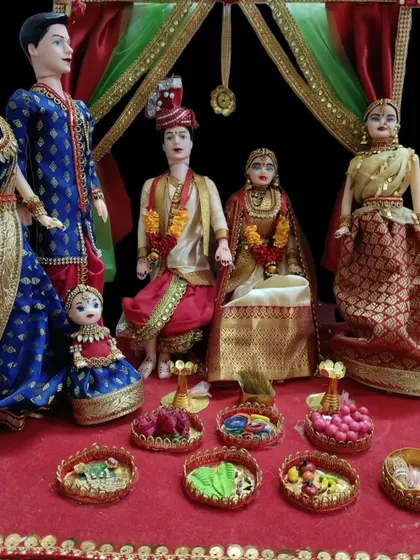 A wedding doll set showing the bride and groom under a decorative canopy, surrounded by their family members.