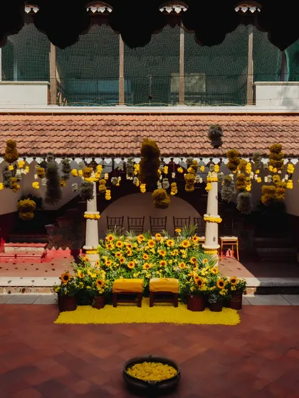 The full Haldi stage setup, with a backdrop of sunflowers and hanging floral strings, creating a vibrant and traditional ambiance.